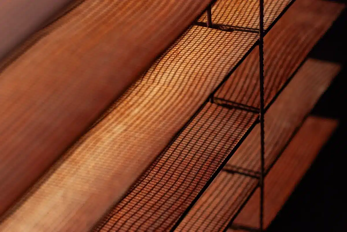 Closed blinds blocking sunlight through a window to reduce heat gain indoors