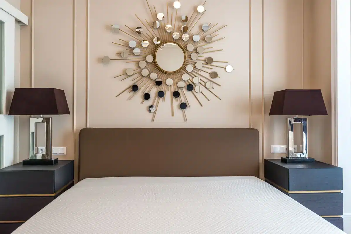 Circular mirror surrounded by metallic discs arranged in three concentric rings creating a radial sunburst effect