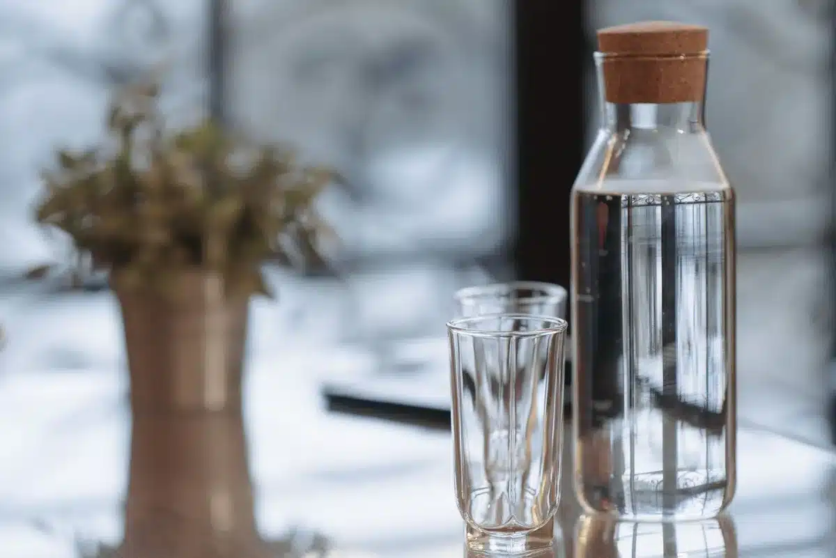 Elegant glass carafe and reusable bottles displayed together, emphasizing sustainable serving options