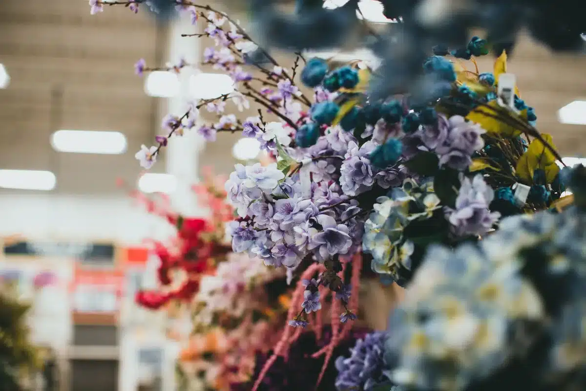 Colorful artificial flowers and craft stems arranged in small decorative vases