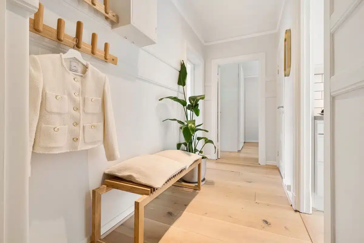 Minimalistische Eingangshalle mit geschwungenem Wandgestell für Mäntel und Zubehör