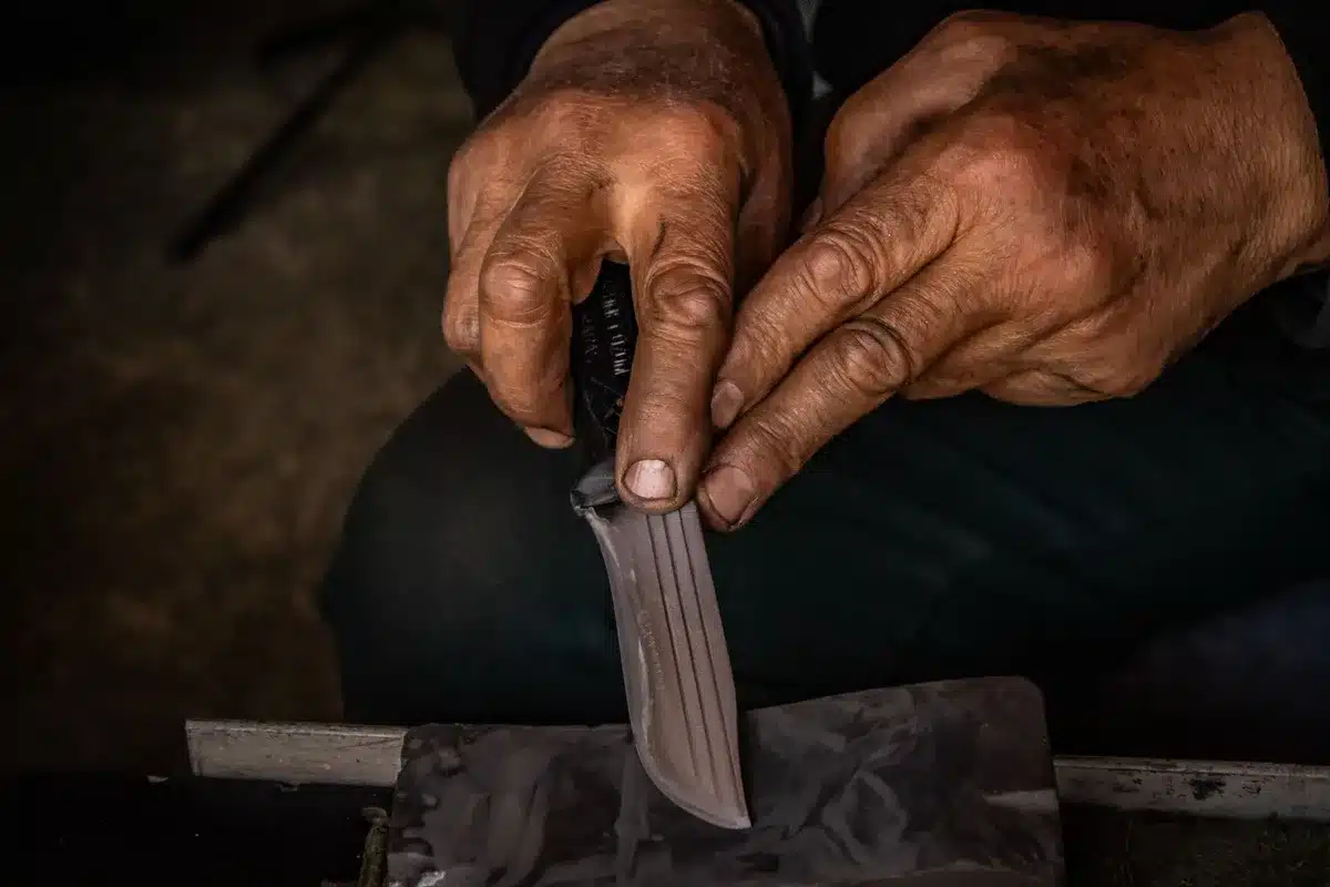 Metal file sharpening a blade edge to dinner knife sharpness