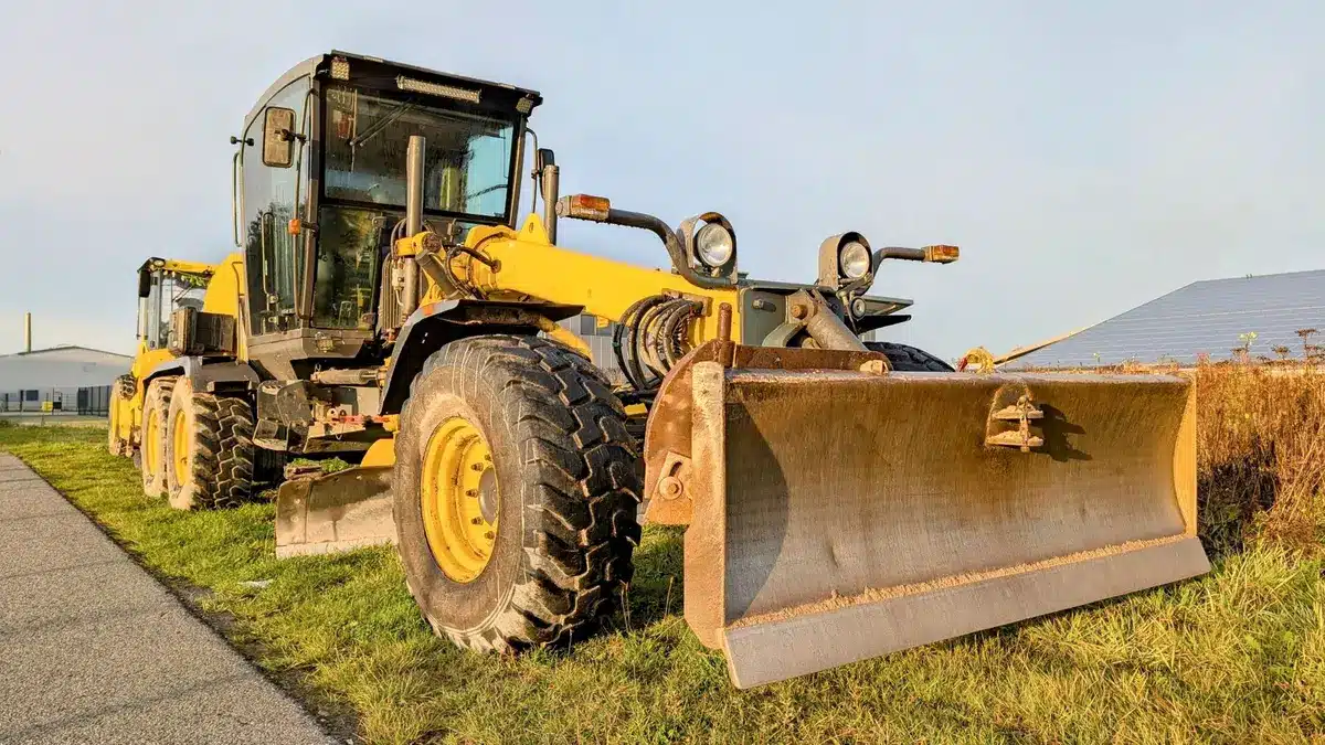 Contractor using grading equipment to reshape and crown a gravel driveway surface
