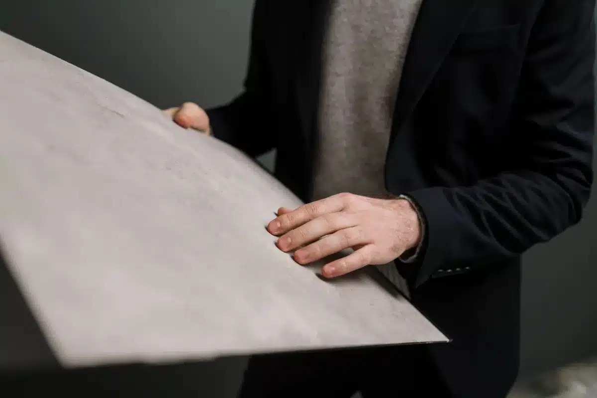 Two drywall sheet samples held side by side showing green and white facing materials.