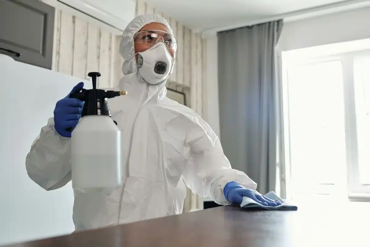 Person wearing protective gloves and mask while cleaning