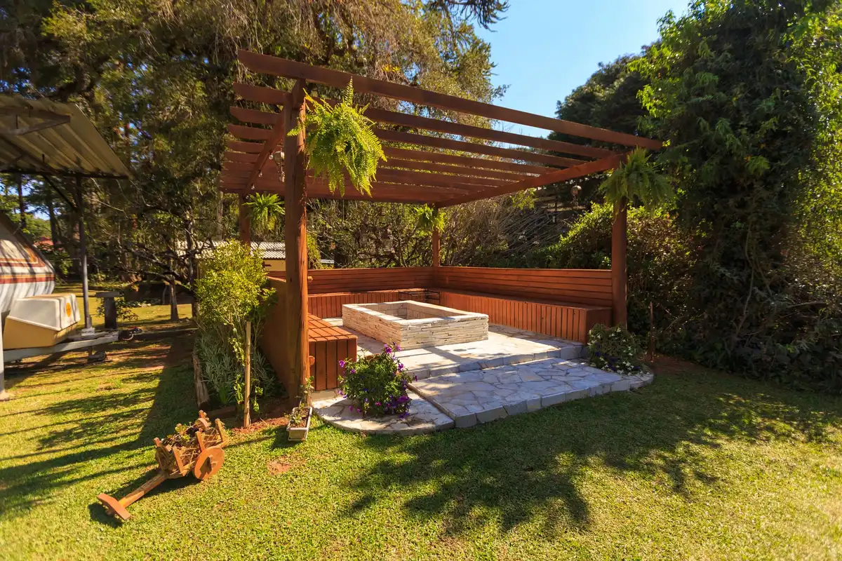 Pergola structure attached to a house providing filtered shade over a patio dining area