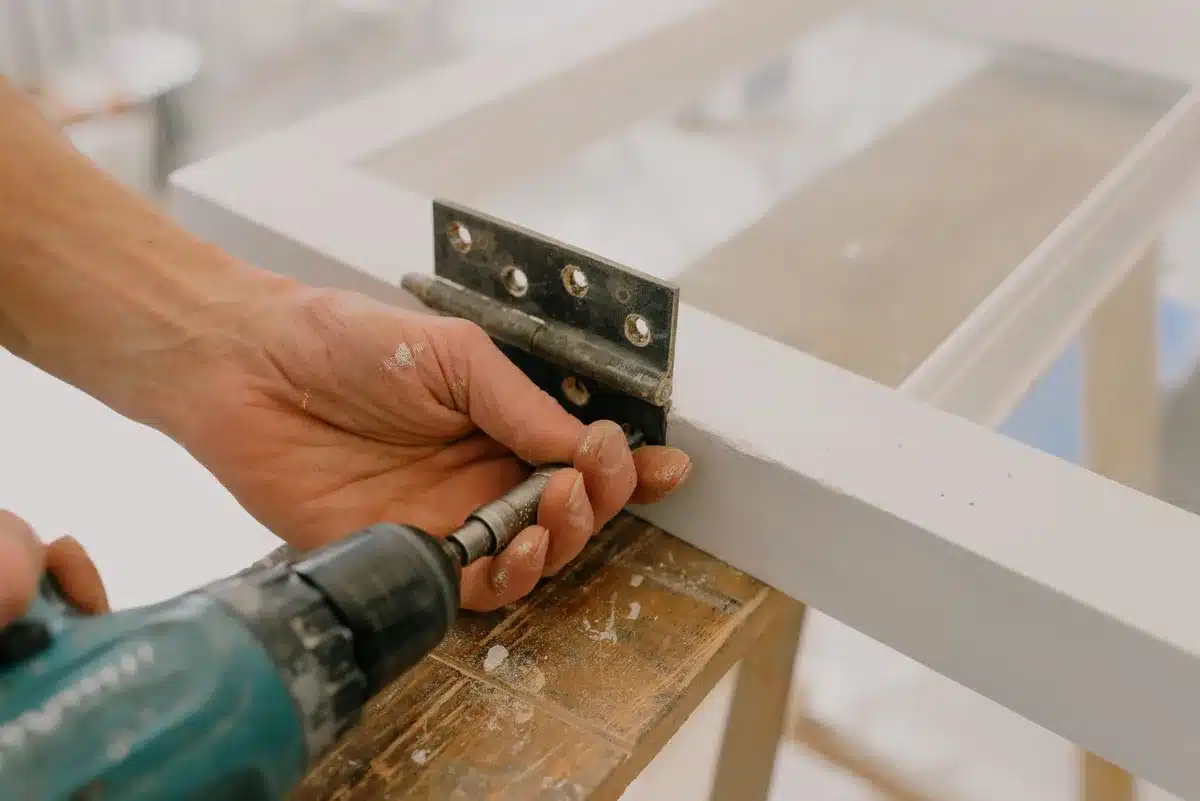 Wooden shutters being joined with heavy-duty hinges on a work surface
