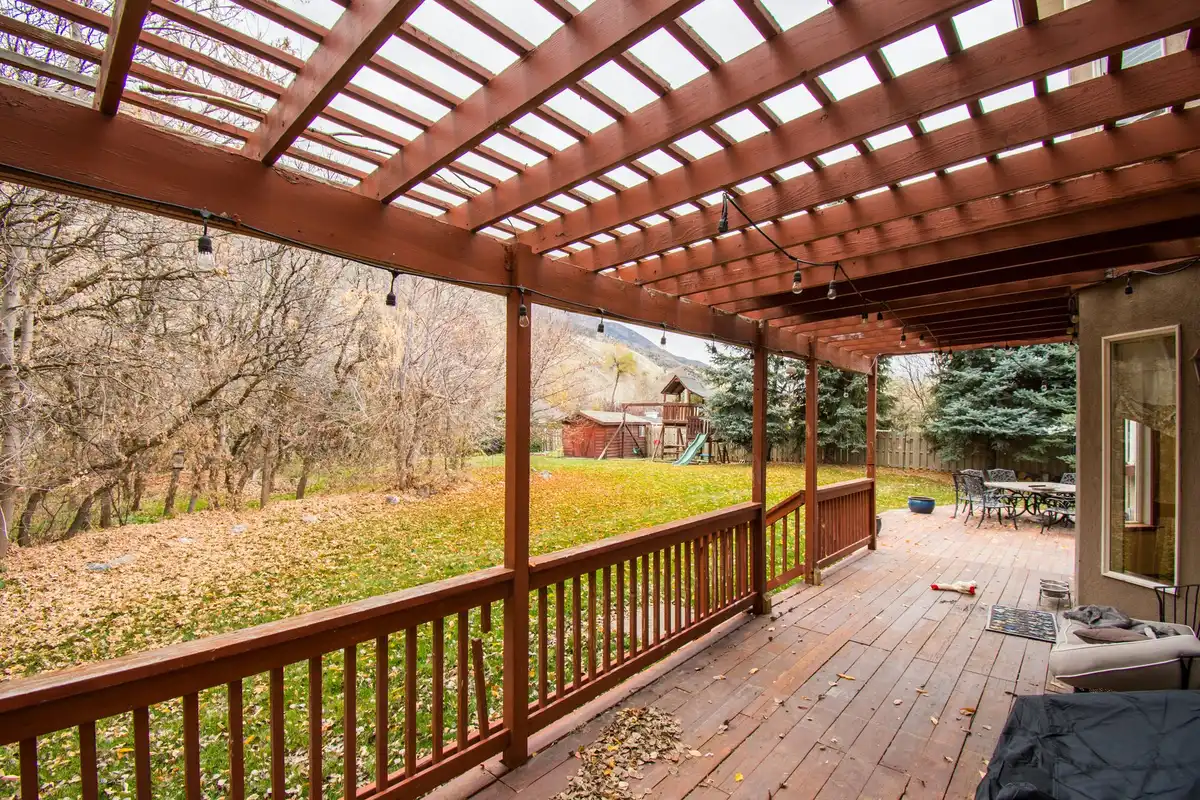 Decorated privacy screen with hanging planters and warm string lights
