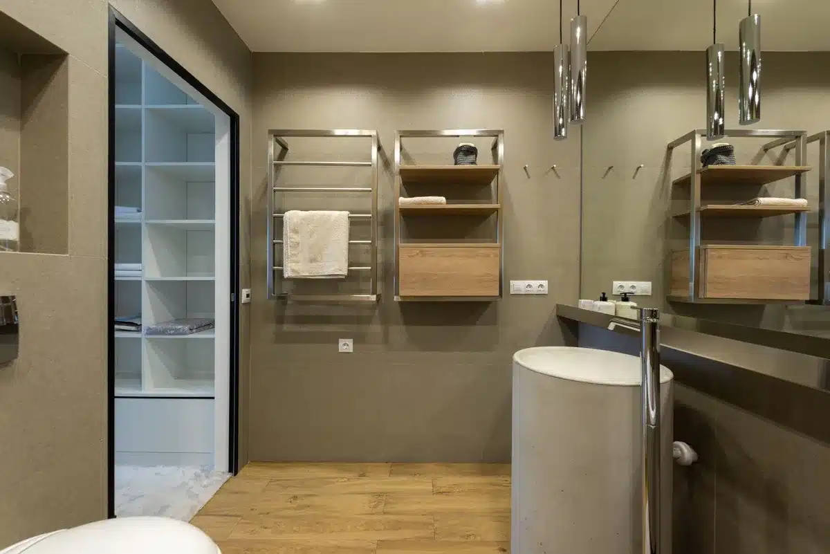 Tall narrow storage tower in a small bathroom holding rolled towels and supplies