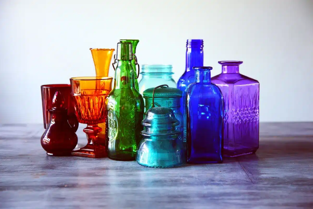 Sammlung von farbigen Vintage-Trinkgläsern in verschiedenen Farbtönen wie Kristall, Rosa und Blau