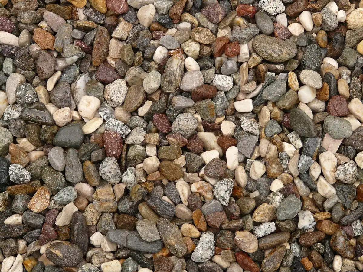 Close-up of gravel driveway with small soil mound between stones