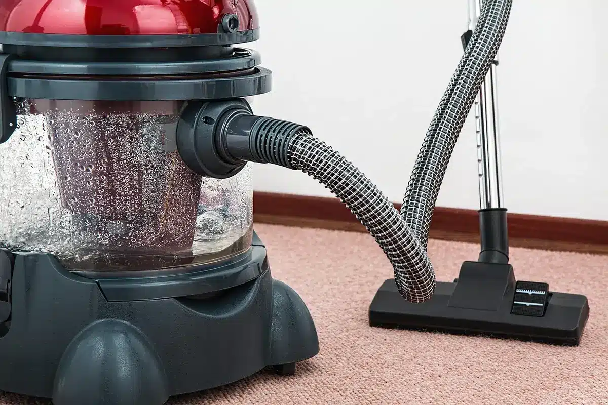 Shop vacuum operating in a workshop environment collecting dust and debris