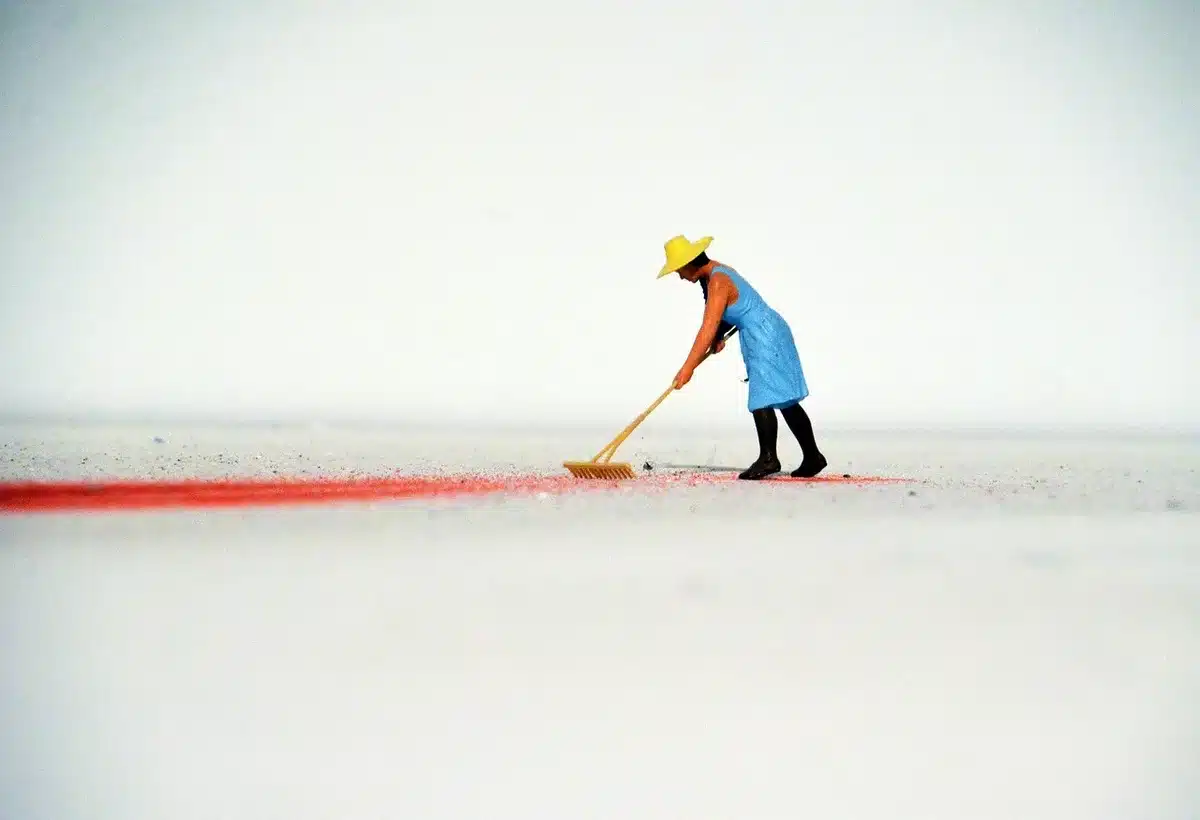 Person installing wooden garden edging, digging shallow trench