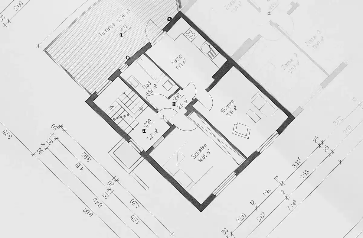 Hand drawing a floor plan on graph paper with dimensions for irregular rooms