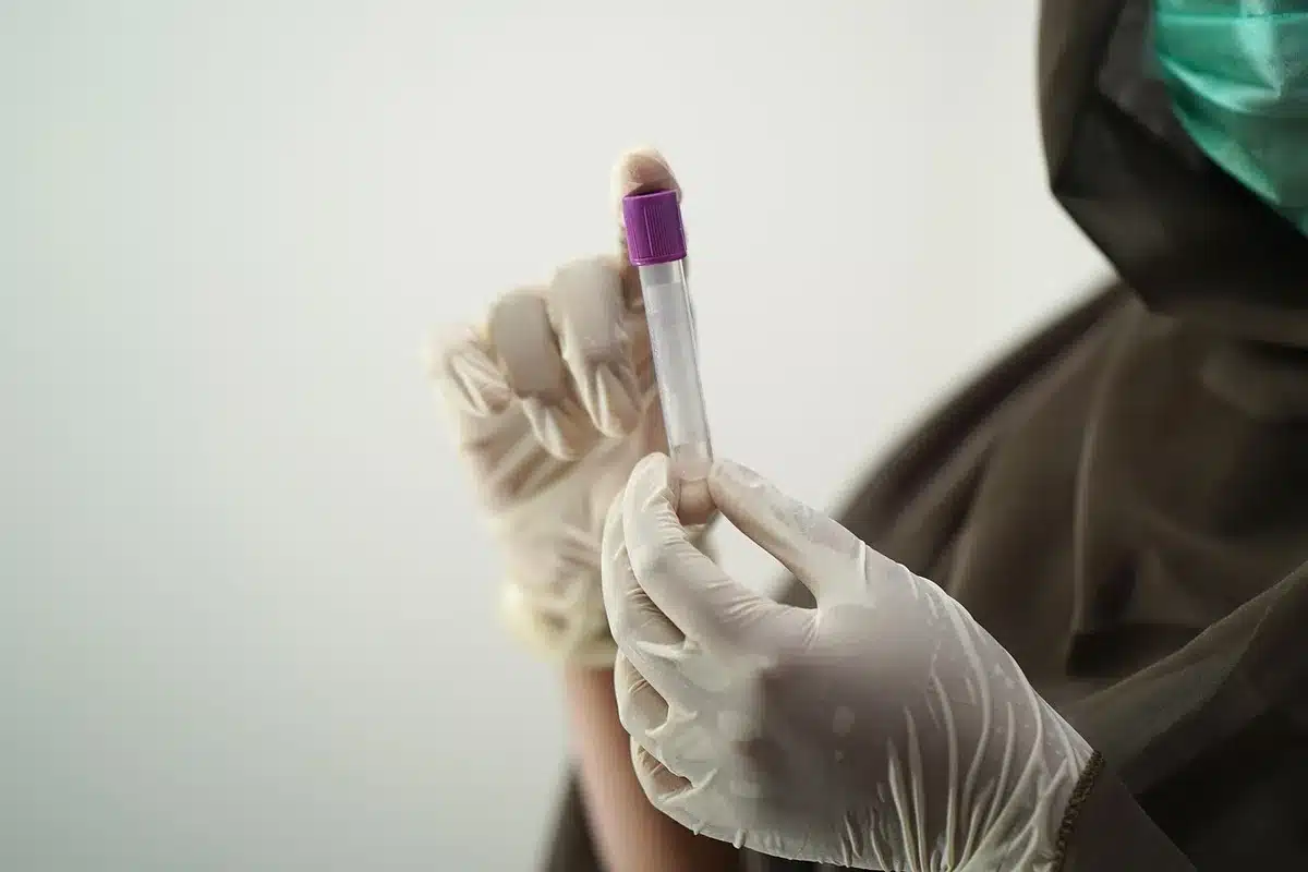 A certified lab technician examining a ceiling sample under magnification to test for asbestos fibers.