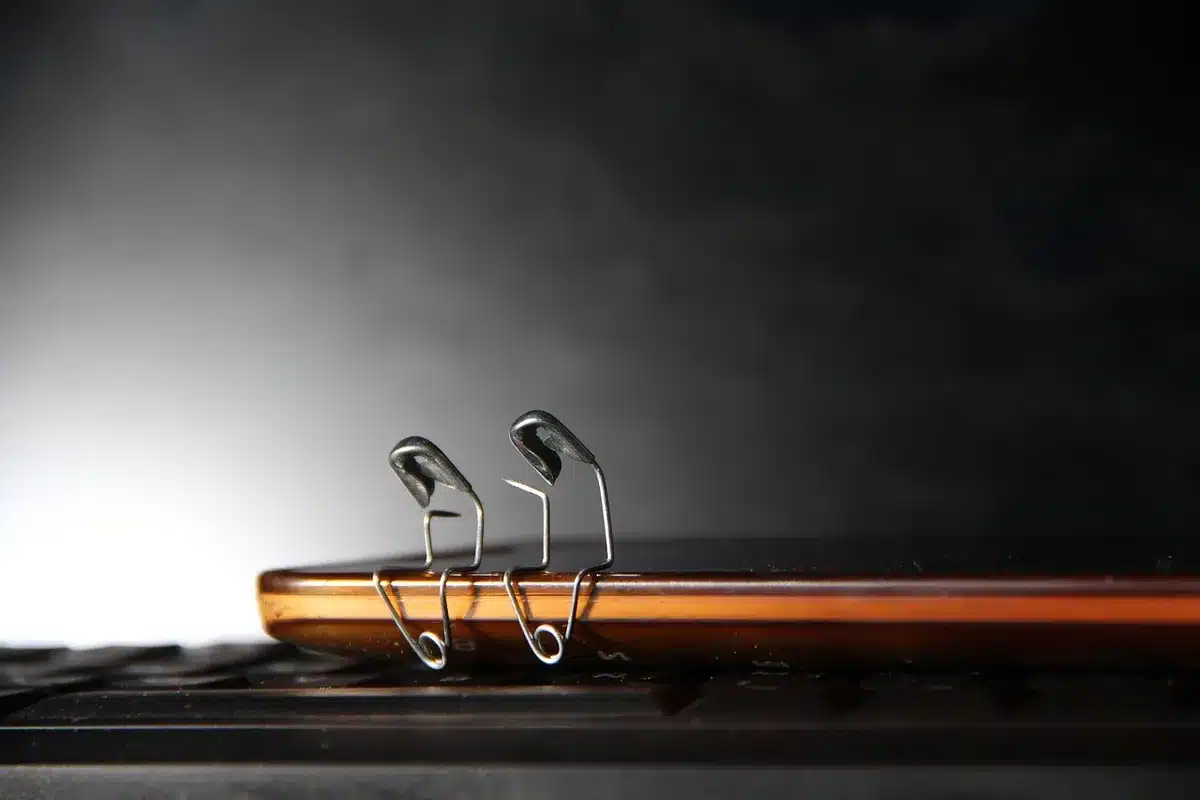 Safety pin fastening a towel hem around a metal ring ready to hang