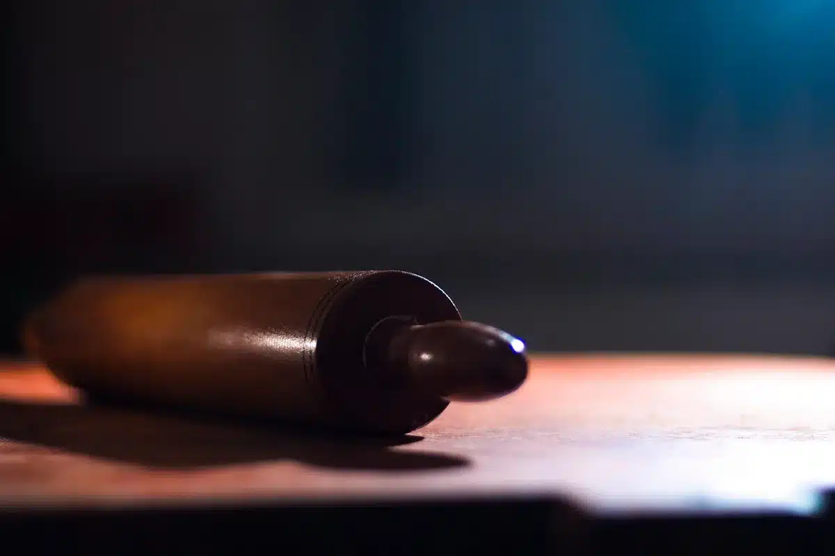 Painted glass jar filled with wooden cooking utensils on a kitchen countertop