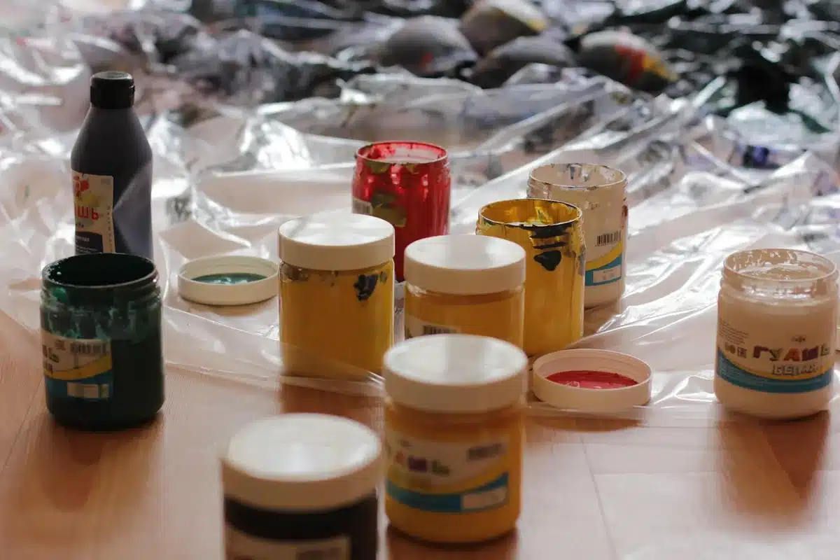 Plastic container being spray painted outdoors in multiple thin coats