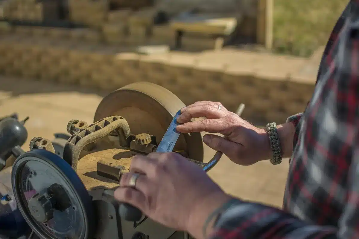 Mower blade clamped in a bench vise ready for sharpening