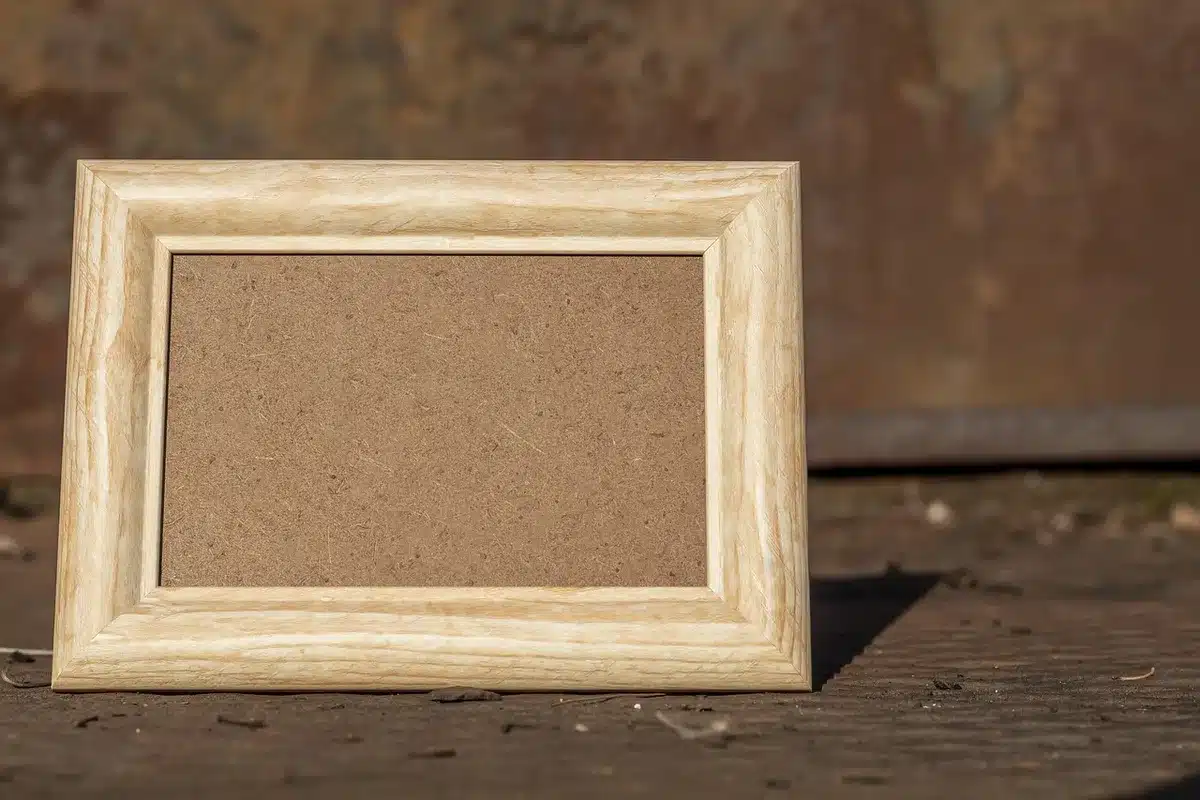 Close-up of hands pressing clay into a missing corner of an ornate frame