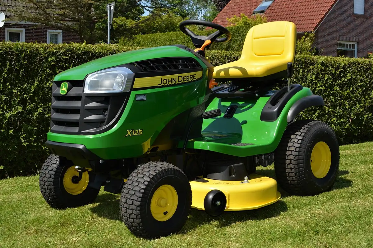 Ride-on mower pulling a homemade chain-link drag across a lawn