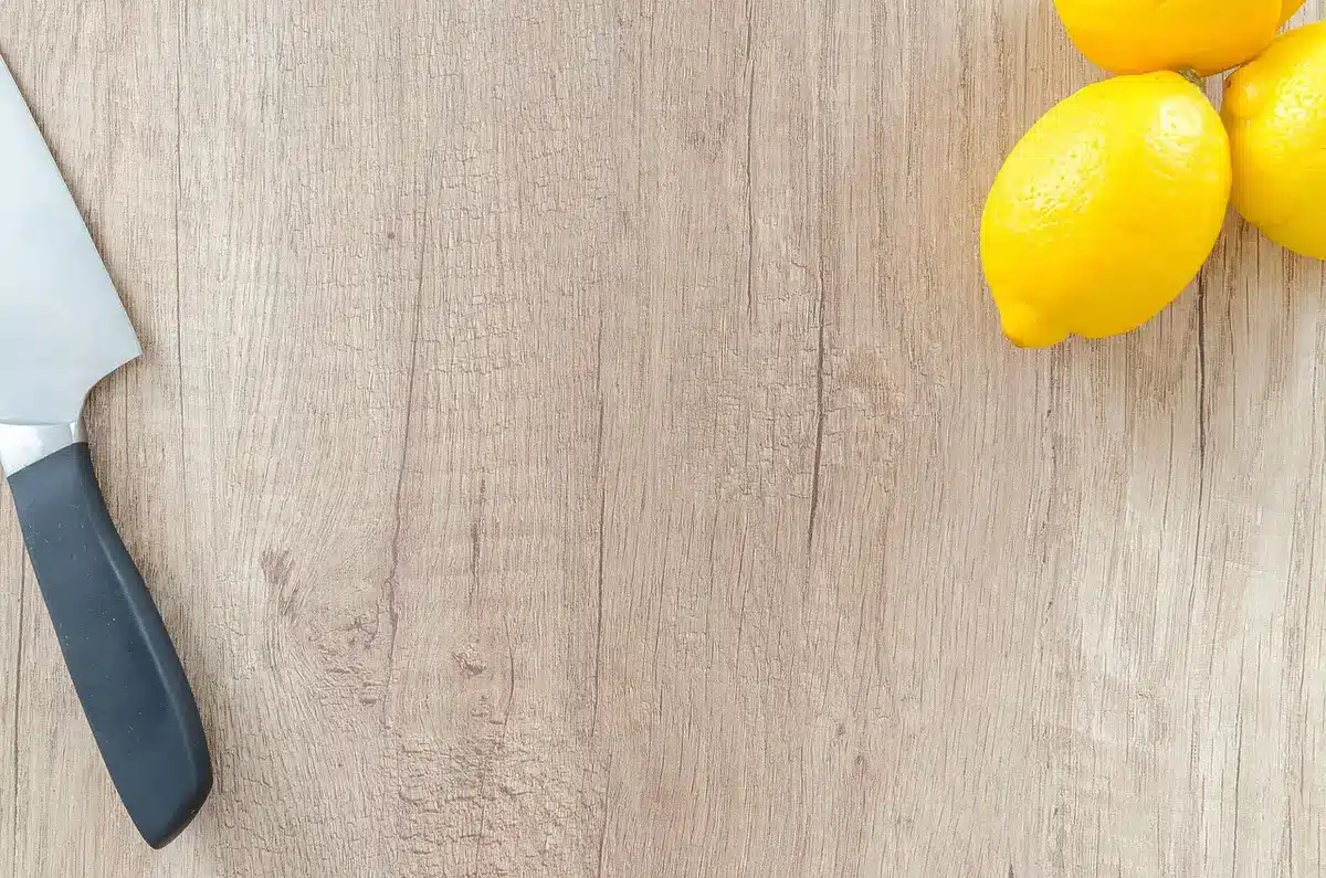 Hands arranging wooden log slices in a straight line on a tabletop