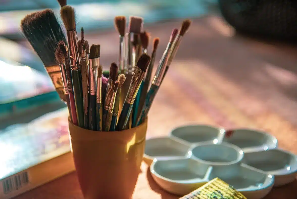 Pre-stretched canvases, jars of joint compound and brushes laid out on a table