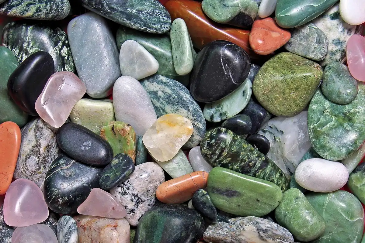 Hands positioning pebbles inside a lined bowl mold while applying adhesive