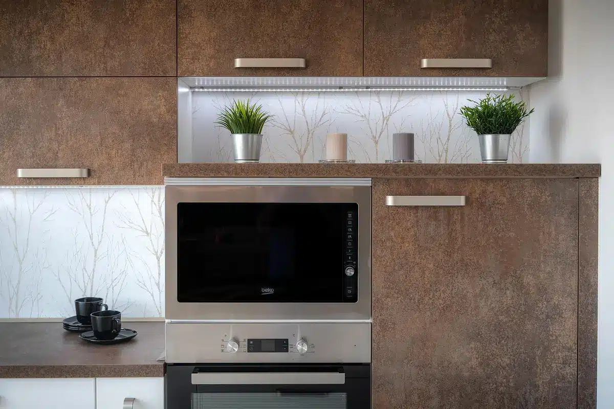 Hands assembling a DIY pizza-pan countertop tray on a bright kitchen island