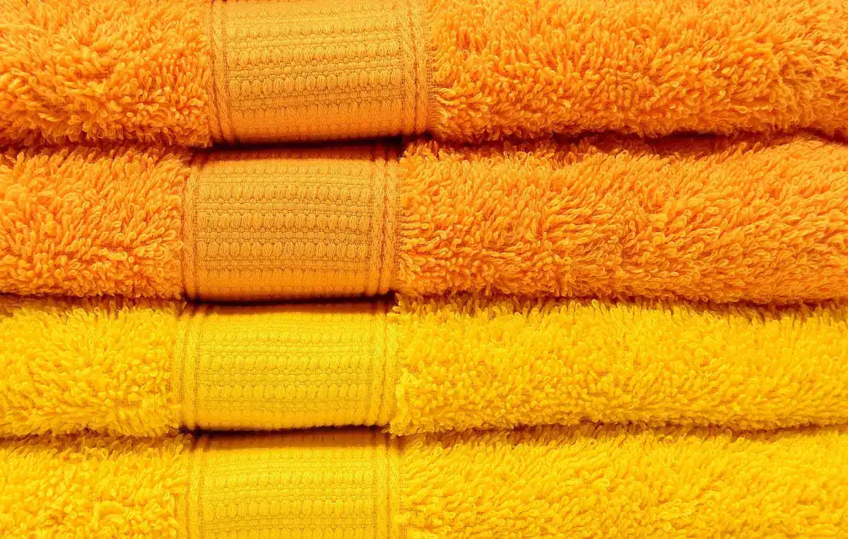 Cotton shower curtain hanging in a warm bathroom showing fabric texture