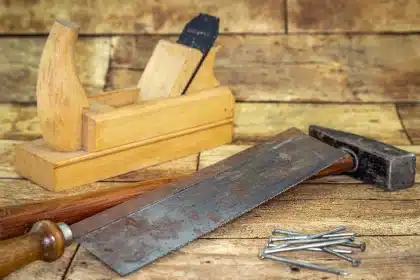 Sunlit porch with redwood boards and hands arranging them on a bright workbench