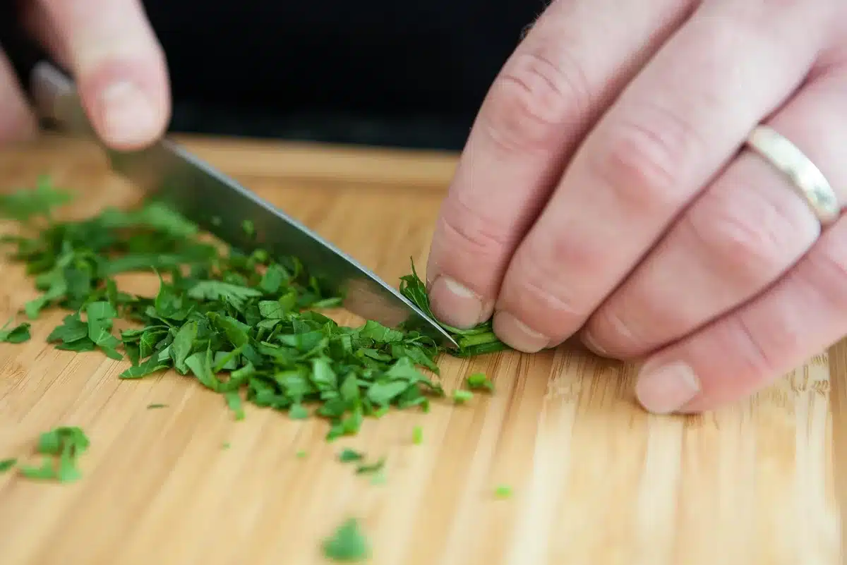 Hand-held tri-face sharpener with angle guide being used on a blade
