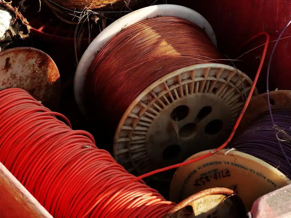 A copper coil positioned over a wood fire beside a tub, heating water by natural circulation