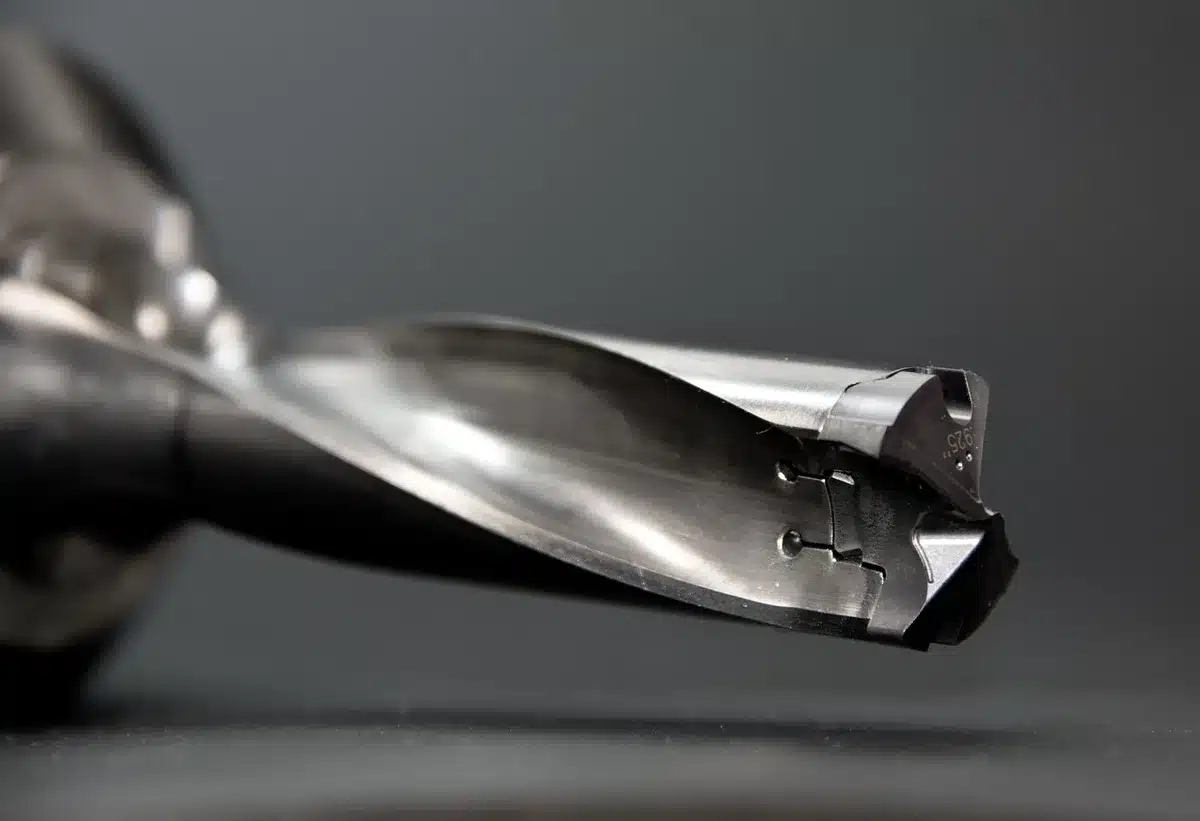 Hands drilling a small hole in a ceramic figurine with diamond bit and water