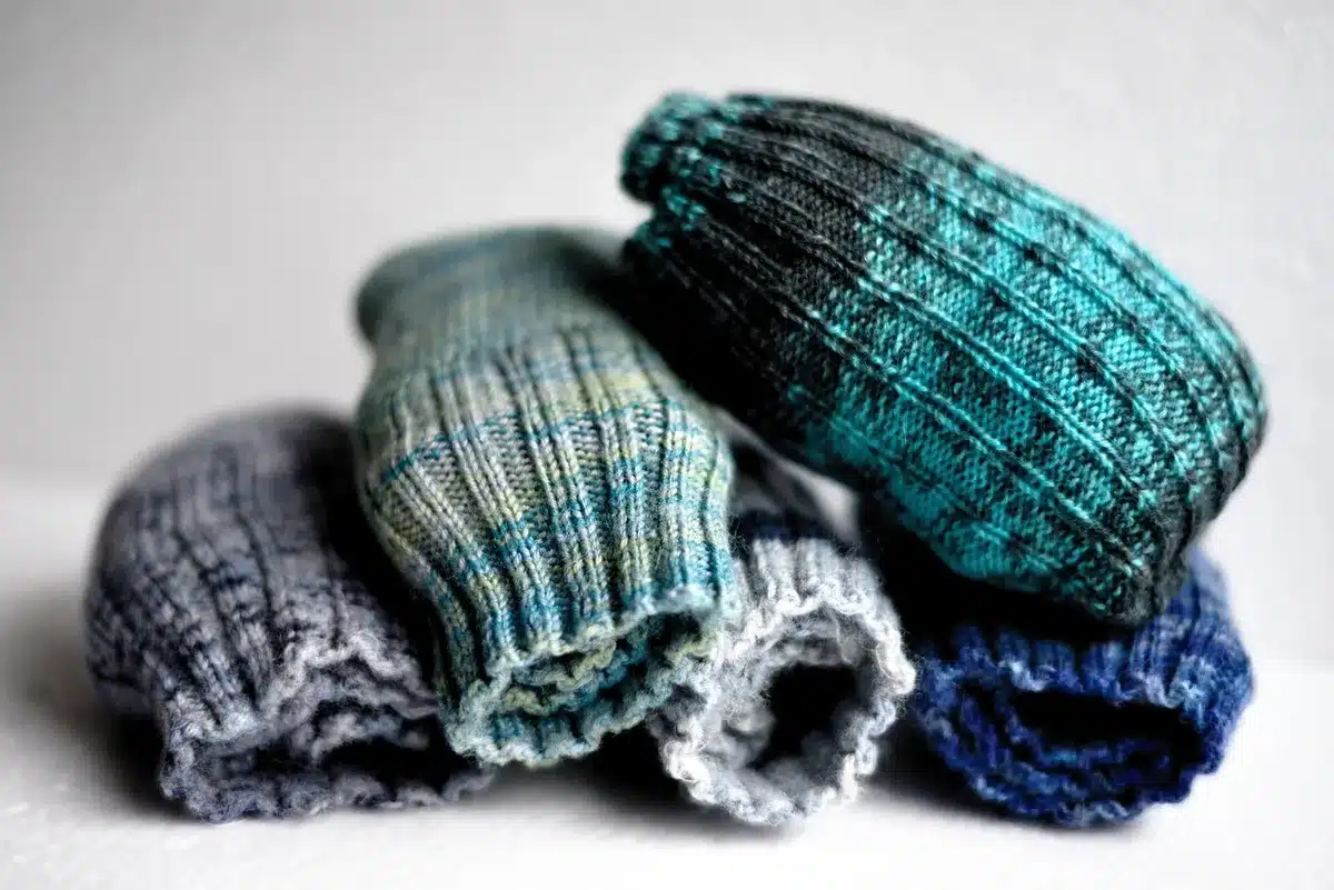 Sock-wrapped cans decorated with googly eyes and yarn hair