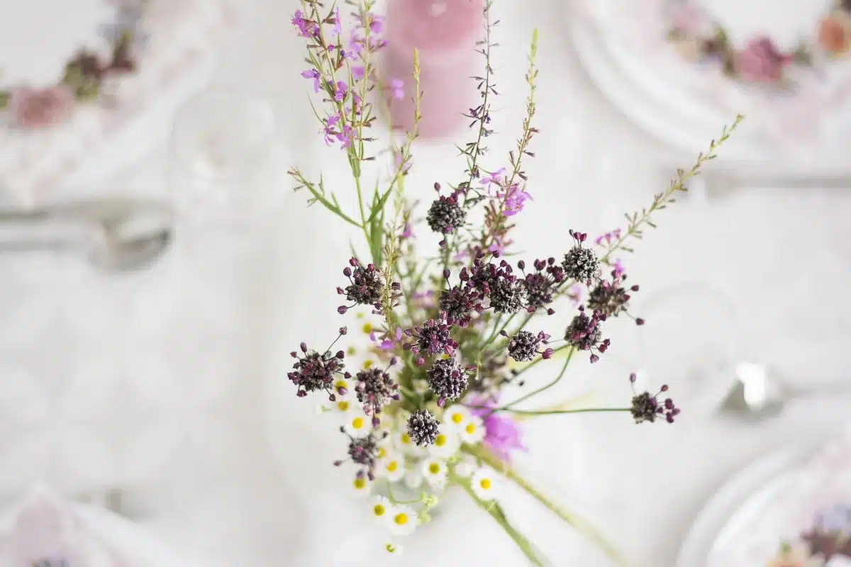 Partially assembled paper flower wreath laid out on a table with glue gun