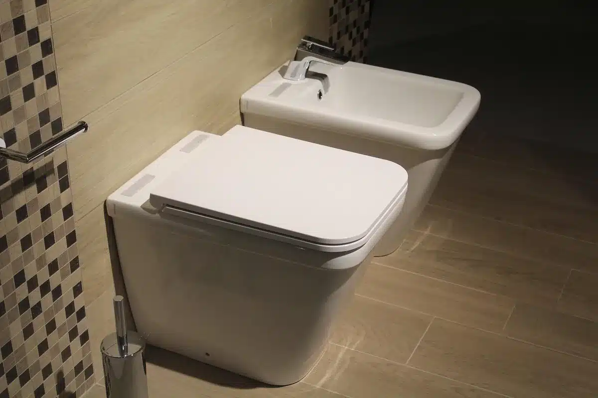 Mesh container on a rail holding spare toilet rolls