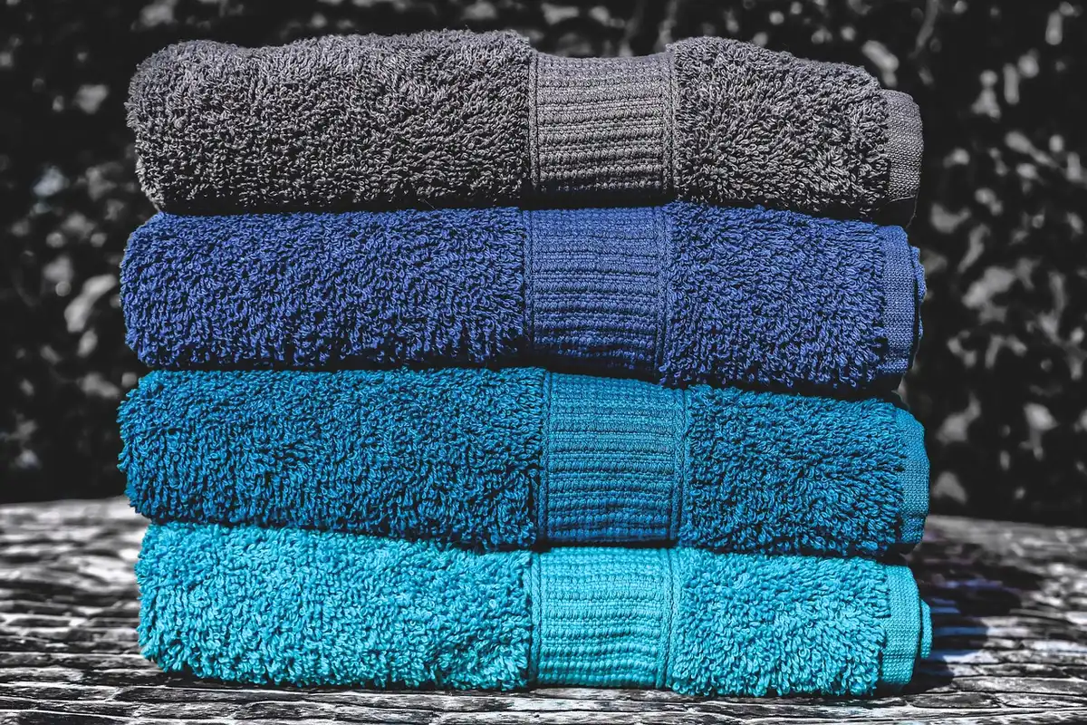 Stacked rolled towels displayed on wall holders beside a vanity