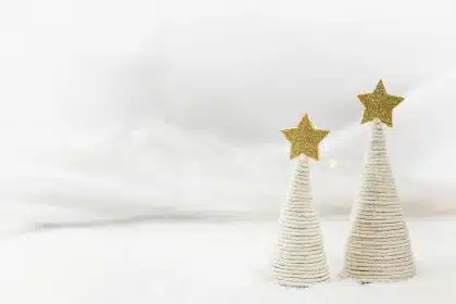 Three twine-wrapped bottles on a sunny kitchen table with craft supplies