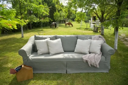Sunlit patio with colorful outdoor throw pillows and a sewing kit on a chair